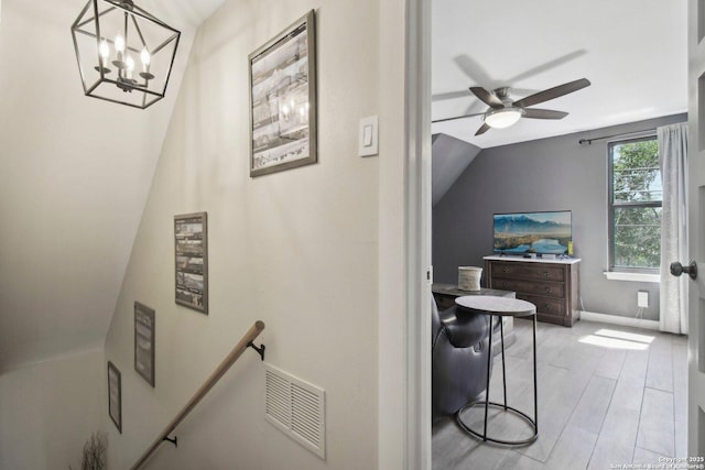 bathroom featuring visible vents, wood finished floors, baseboards, ceiling fan with notable chandelier, and lofted ceiling