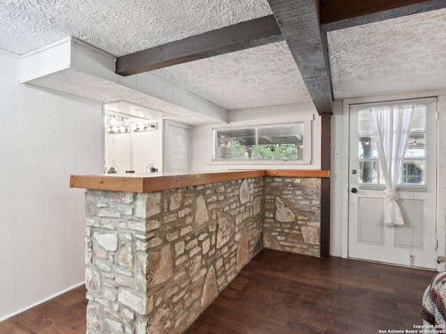 bar with a textured ceiling and wood finished floors