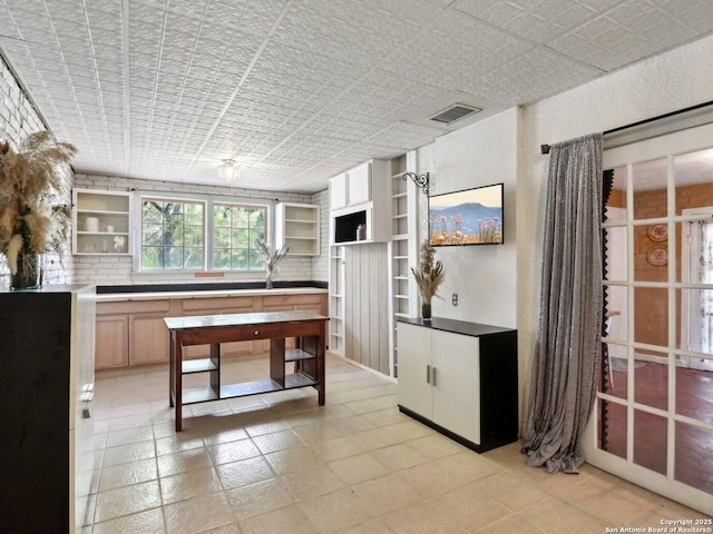 kitchen with visible vents, open shelves, built in shelves, light tile patterned floors, and an ornate ceiling