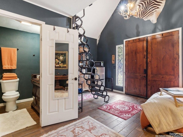 interior space with high vaulted ceiling, a notable chandelier, and hardwood / wood-style floors