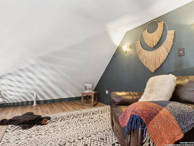 bedroom featuring wood finished floors and lofted ceiling