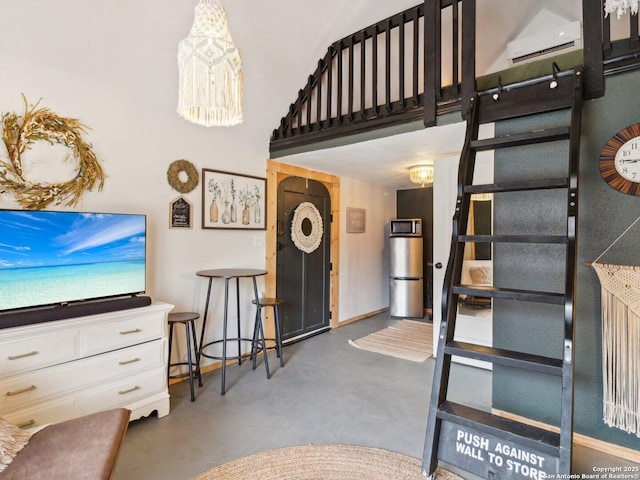 staircase featuring baseboards, finished concrete flooring, a wall mounted AC, and a high ceiling