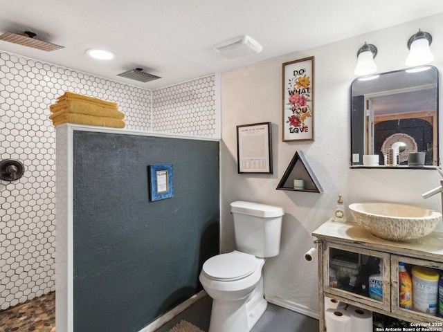 full bath with vanity, visible vents, toilet, baseboards, and walk in shower