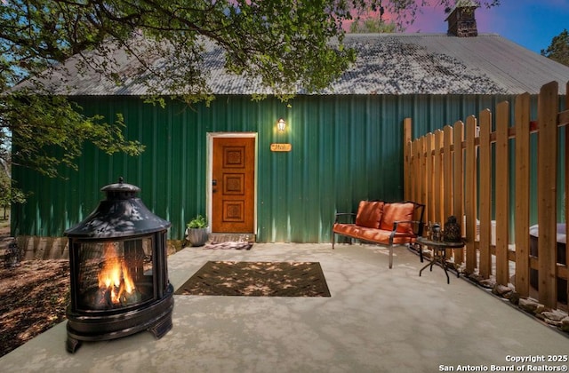 view of outbuilding with fence and a fire pit