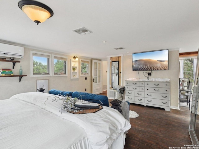 bedroom with visible vents, wood finished floors, and a wall mounted air conditioner