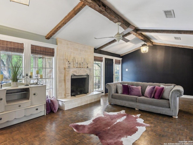 living area featuring a ceiling fan, visible vents, lofted ceiling with beams, and a high end fireplace
