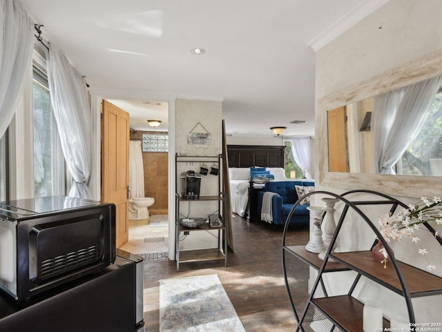 interior space featuring crown molding, dark wood-style flooring, and a healthy amount of sunlight