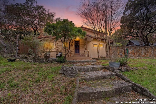 view of front of home featuring fence and stucco siding