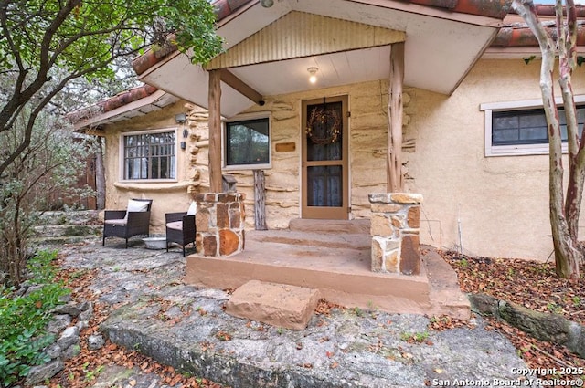 view of exterior entry with stucco siding and stone siding