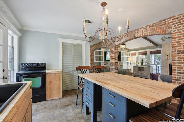 kitchen with black electric range oven, a breakfast bar, a sink, wood counters, and a notable chandelier