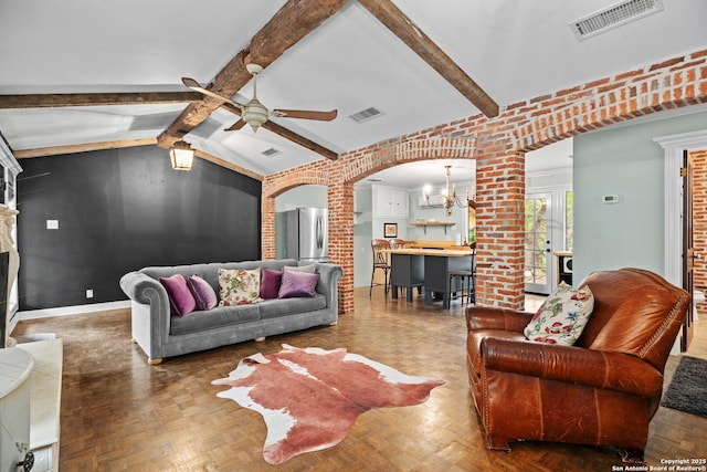 living room featuring visible vents, arched walkways, ceiling fan with notable chandelier, and ornate columns