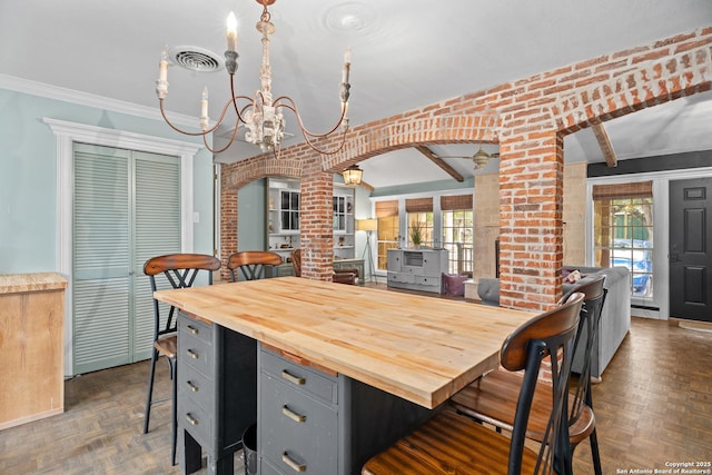 dining space with arched walkways, decorative columns, a chandelier, and visible vents