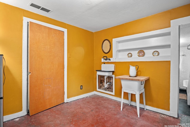 interior space featuring visible vents, baseboards, and finished concrete floors