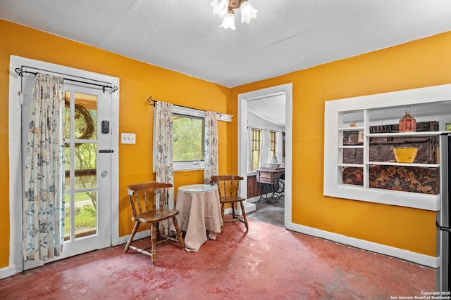 dining room with baseboards and finished concrete flooring