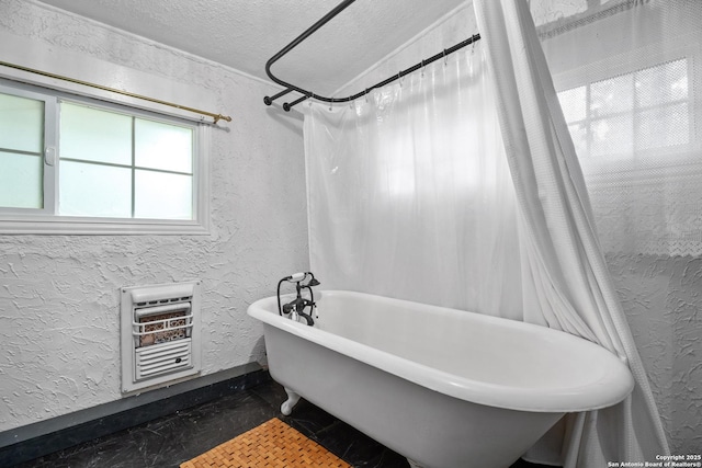 bathroom featuring a textured ceiling, a textured wall, heating unit, and a freestanding bath