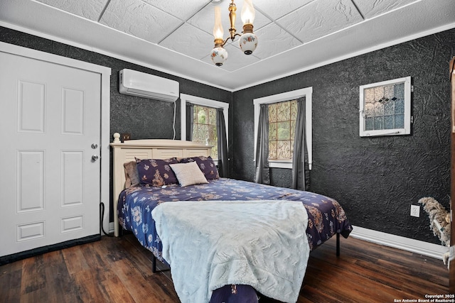 bedroom with an inviting chandelier, baseboards, a wall mounted air conditioner, and wood finished floors