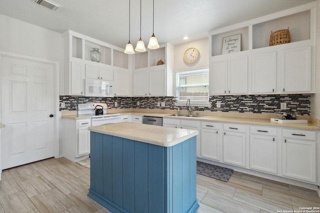kitchen with visible vents, tasteful backsplash, a sink, white appliances, and white cabinetry