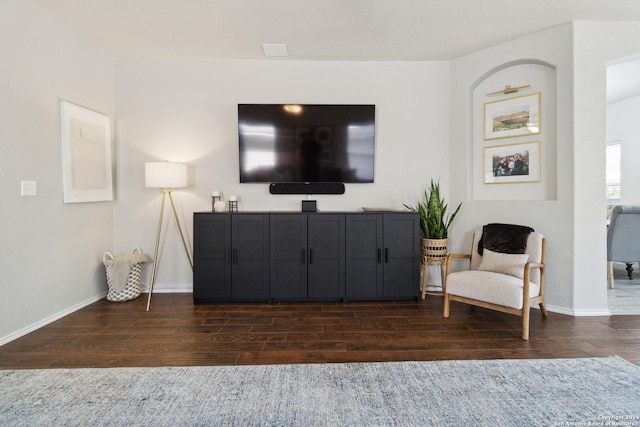living area featuring dark wood-type flooring and baseboards