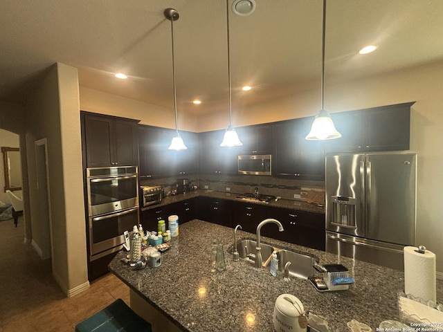 12606 Ozona, San Antonio, TX 78245 - kitchen featuring dark stone counters, stainless steel appliances, hanging light fixtures, and backsplash