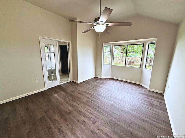 empty room featuring a ceiling fan, a wealth of natural light, lofted ceiling, and dark wood-type flooring