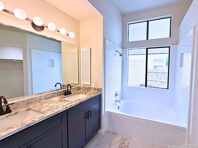 bathroom featuring double vanity, tiled shower / bath, a sink, and marble finish floor