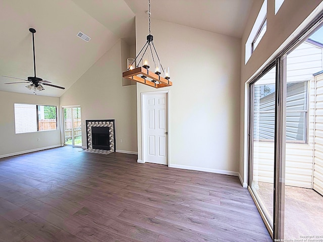 unfurnished living room featuring visible vents, baseboards, wood finished floors, and high vaulted ceiling