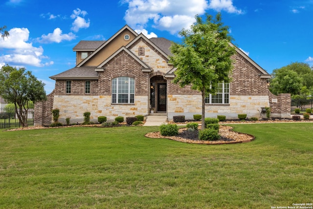 view of front of house featuring roof with shingles, a front yard, fence, and stone siding