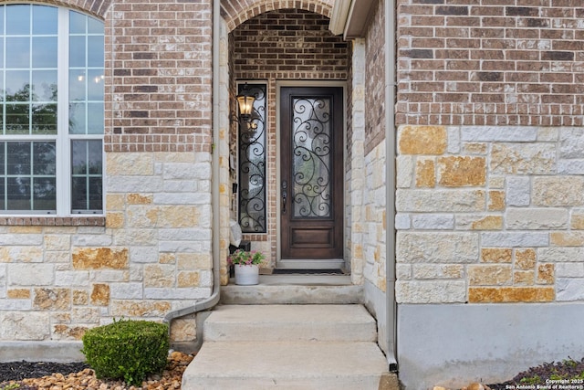 doorway to property with stone siding and brick siding