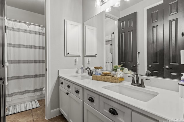 full bath featuring double vanity, a sink, tile patterned floors, and toilet
