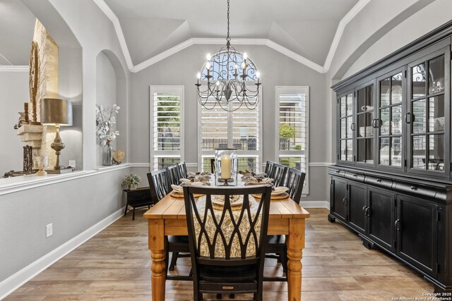 dining room with plenty of natural light, a chandelier, and vaulted ceiling