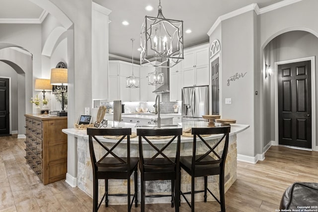 kitchen featuring ornamental molding, stainless steel refrigerator with ice dispenser, white cabinetry, tasteful backsplash, and a notable chandelier