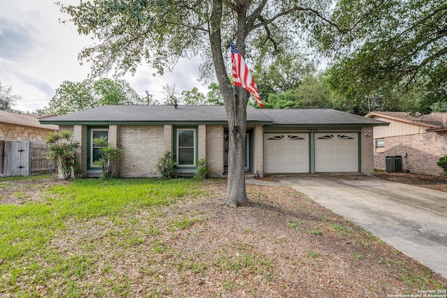 ranch-style house with fence, cooling unit, brick siding, concrete driveway, and an attached garage