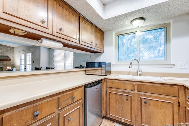 kitchen featuring a sink, brown cabinets, black microwave, and light countertops