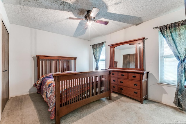 bedroom featuring a ceiling fan, carpet flooring, and a textured ceiling