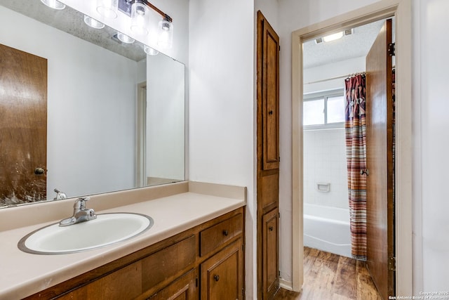 bathroom with vanity, shower / bathtub combination with curtain, and wood finished floors