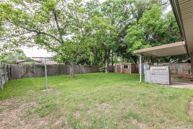view of yard featuring an outbuilding, a fenced backyard, and a storage unit