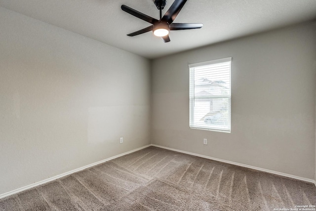 carpeted spare room with baseboards and ceiling fan