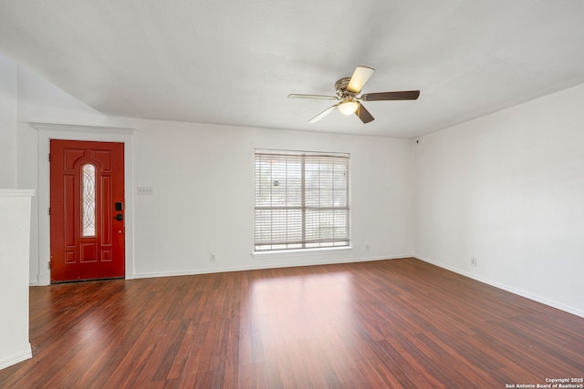 interior space with a ceiling fan, baseboards, and dark wood-style floors