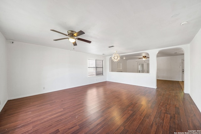 unfurnished living room featuring baseboards, a ceiling fan, arched walkways, and wood finished floors
