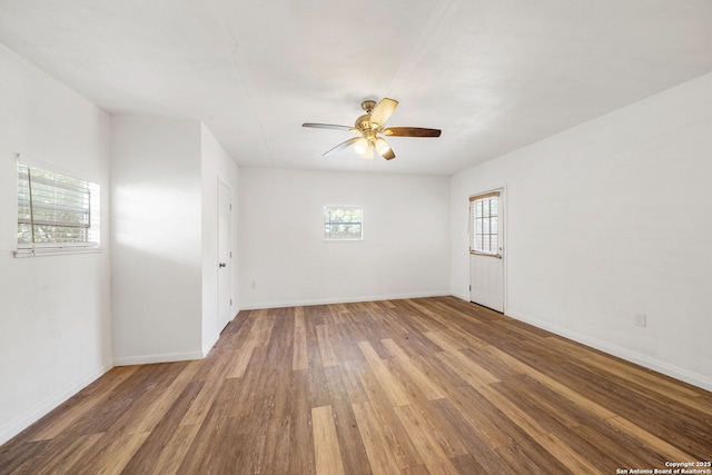 spare room with baseboards, ceiling fan, and wood finished floors