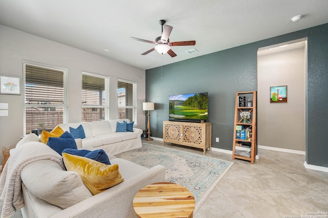 living room featuring baseboards, ceiling fan, and visible vents