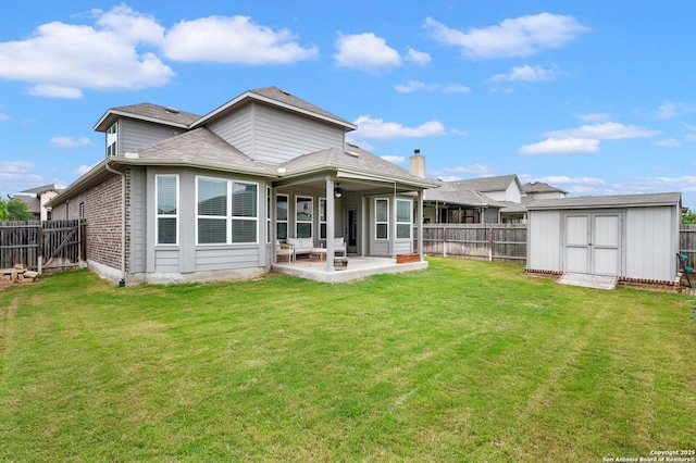 back of house with a fenced backyard, a storage unit, a patio, and a lawn
