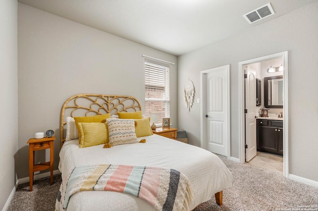 bedroom with visible vents, baseboards, carpet floors, and ensuite bath