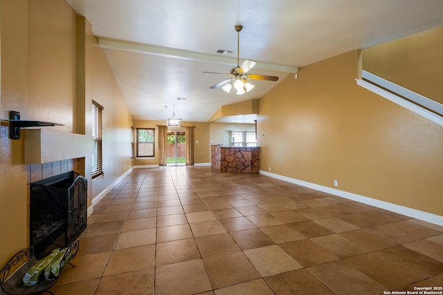 unfurnished living room with visible vents, a fireplace, baseboards, ceiling fan, and vaulted ceiling with beams