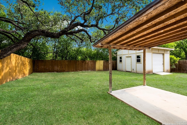 view of yard with a fenced backyard, a patio, and an outbuilding