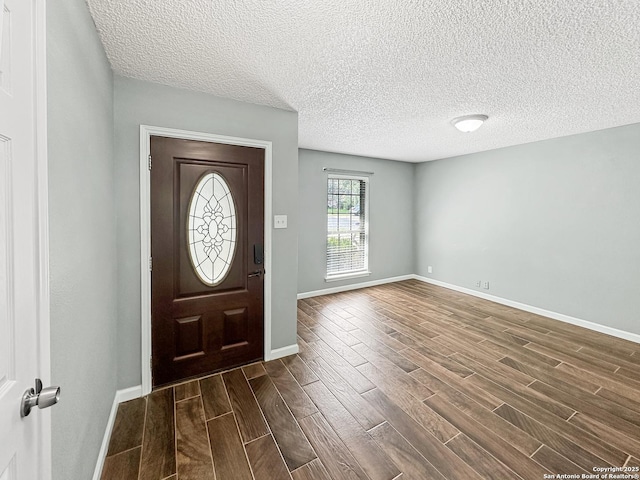 foyer with a textured ceiling, baseboards, and wood tiled floor
