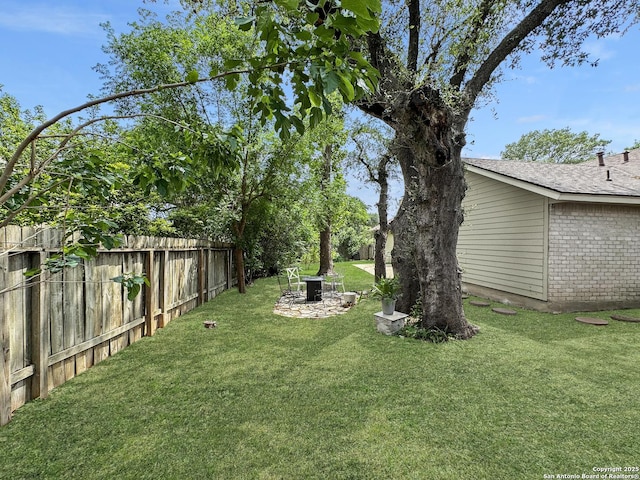 view of yard featuring fence and a fire pit