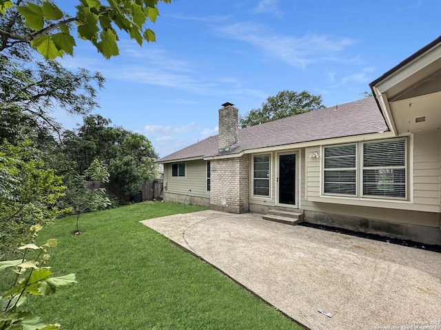 rear view of house with a chimney, fence, a yard, a patio, and entry steps