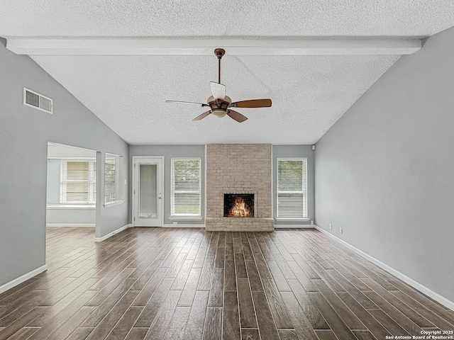unfurnished living room featuring a ceiling fan, dark wood-style floors, a textured ceiling, and visible vents