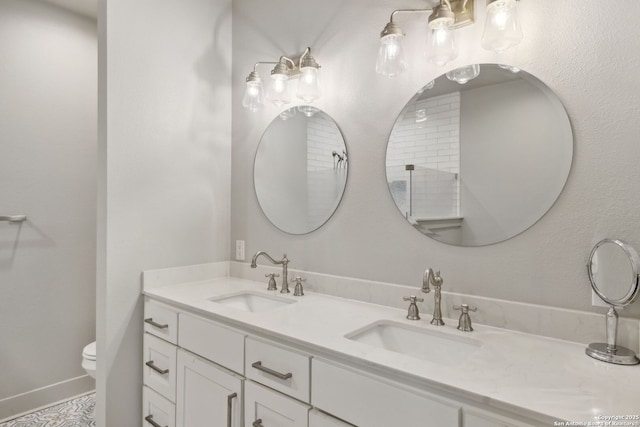 full bathroom featuring double vanity, toilet, and a sink